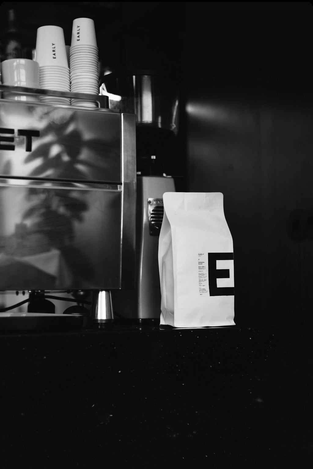E1 Espresso Blend Coffee bag with a brand logo next to a Rocket E9 Espresso coffee machine